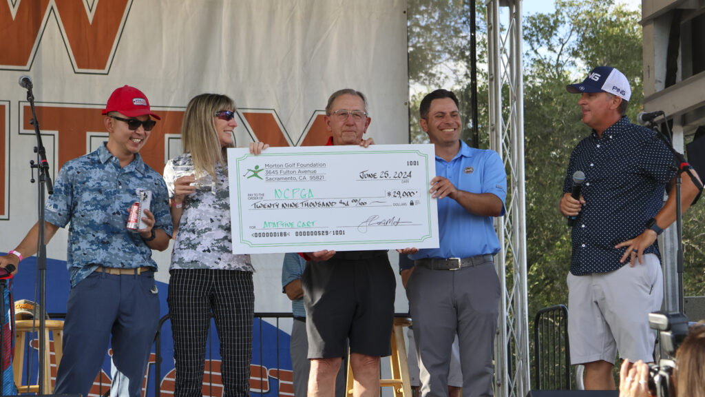 Members of the Northern California PGA smiling while holding a giant check for $29,000 to pay for an adaptive cart.