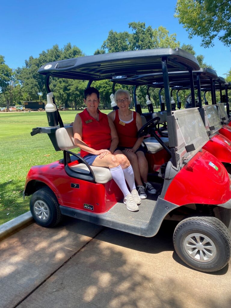 Two women sitting on golf cart