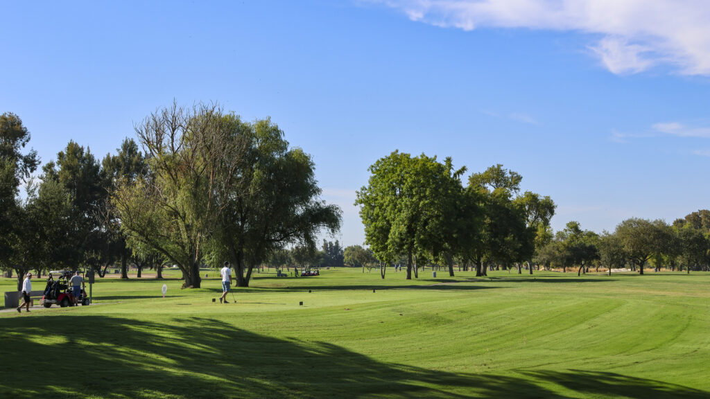 A wide shot of a golfer teeing off on the 7th hole at Haggin Oaks.