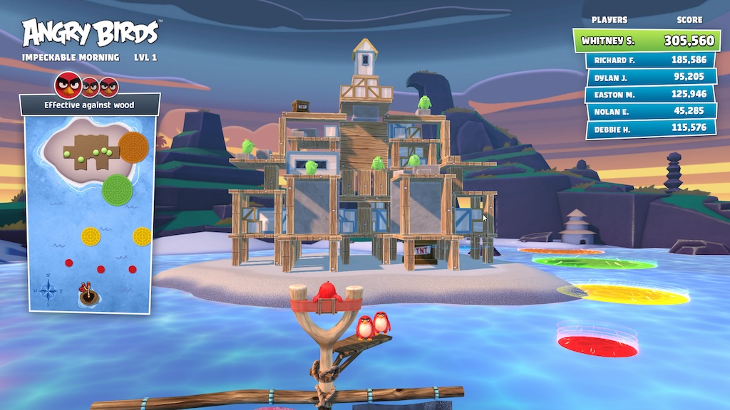 A screenshot of the Angry Birds game on Toptracer. The player is aiming their red bird at the wooden structure that several green pigs are standing on. On the right side of the image is a leaderboard with high scores. On the left side is a top-down map of the level.