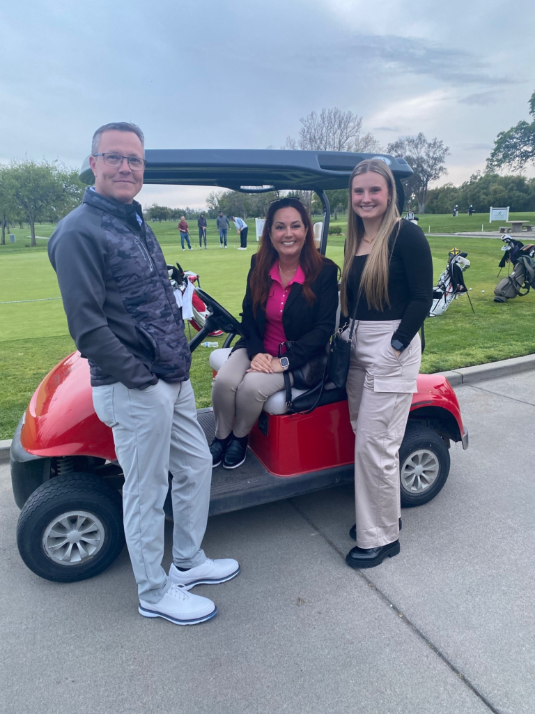 Murray, Kristan and Soliel on cart in front of putting green