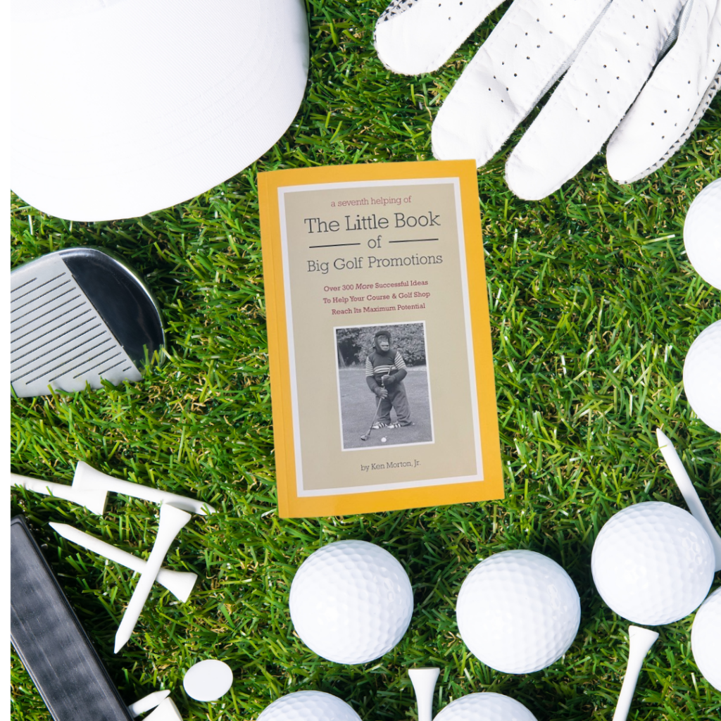 The little book of Big Golf Promotions on green grass background with golf club, glove, hat, balls and tees surrounding it